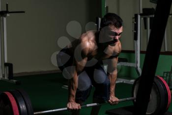 Muscular Man Lifting Dead Lift In The Gym