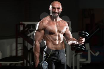 Mature Man Working Out Biceps In A Health Club