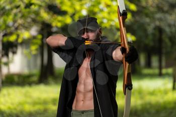 Beard Man With A Bow And Arrows In The Woods