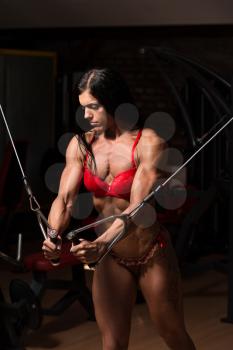Young Woman In Underwear Is Working On Her Chest With Cable Crossover In A Dark Gym