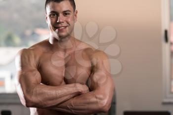 Portrait Of A Physically Fit Man Showing His Well Trained Body In Gym