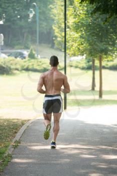 Young Bodybuilder Running In Park Area - Training And Exercising For Trail Run Marathon Endurance - Fitness Healthy Lifestyle Concept