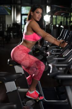 Fitness Girl Exercising On Bike Working Out In A Gym