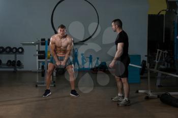 Handsome Guy Working Out Kettle Bell With Personal Trainer