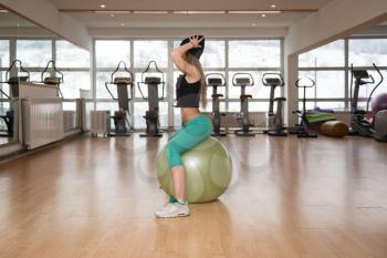 Woman Exercising Pilates Ball Workout Posture In Fitness Club