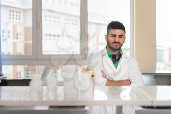 Portrait Of A Arabic Student In A Chemistry Lab Smiling And Looking In The Camera With Hands Folded