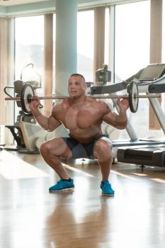 Physically Fit Man Exercising Legs By Doing Squats
