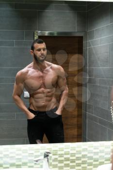 Portrait Of A Physically Fit Man Showing His Well Trained Body In A Bathroom