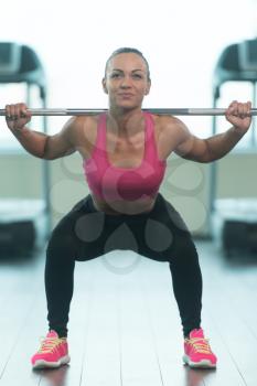 Healthy Fitness Woman Working Out Legs With Barbell In A Gym - Squat Exercise