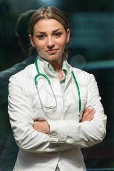 Portrait Of A Beautiful Young Female Doctor Standing Arms Crossed In Office - Successful Woman In Uniform At Work