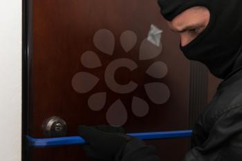 Man With A Black Mask Is Breaking Into A Home