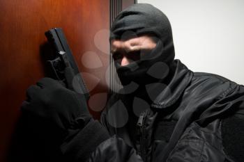 Man With A Black Mask And Gun Is Breaking Into A Home - Standing Behind The Door