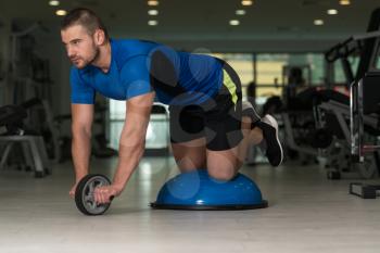Personal Trainer Doing A Exercise For Abs With Bosu Balance Ball As Part Of Bodybuilding Fitness Training