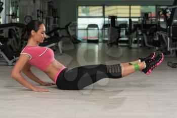 Attractive Woman Exercising With A Resistance Band On Floor In Gym As Part Of Fitness Training