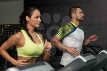 Group Of Young People Running On Treadmills In Gym Or Fitness Club