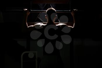 Siluet Handsome Man Athlete Doing Pull Ups - Chin-Ups In The Gym
