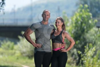Portrait Of A Young Physically Fit Couple Showing Their Well Trained Body Resting After Running - Muscular Athletic Bodybuilder Fitness Model Posing After Exercises