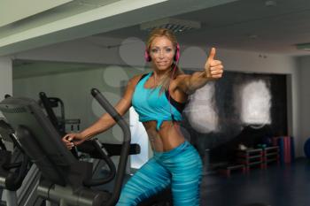 Attractive Mature Woman Doing Aerobics Elliptical Walker In Modern Fitness Center