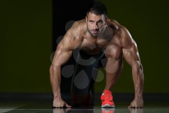 Strong Muscular Men Kneeling On The Floor - Almost Like Sprinter Starting Position