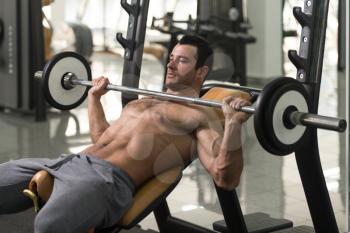 Muscular Hairy Man Doing Heavy Weight Exercise For Chest With Barbell In Gym