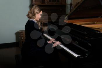 Young Artist in Black Velvet Evening Dress Playing at the Old Wooden Piano Classical Sonata by Gentle Candlelight
