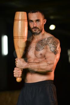 Young Man Exercising With Bowling Pin And Flexing Muscles - Muscular Athletic Bodybuilder Fitness Model Exercises