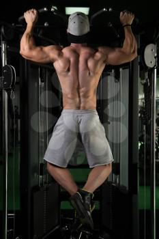 Young Man Athlete Doing Pull Ups - Chin-Ups In The Gym