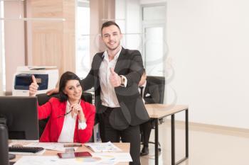 Happy Smiling Cheerful Businesswoman And Businessman With Thumbs Up Gesture