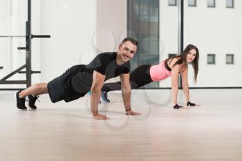 Couple Doing Pushups As Part Of Bodybuilding Training In The Gym