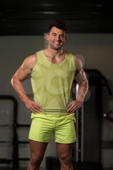 Handsome Young Man Standing Strong in Green T-shirt and Flexing Muscles - Muscular Athletic Bodybuilder Fitness Model Posing After Exercises