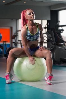 Attractive Woman Resting On Ball After Exercise In Fitness Center