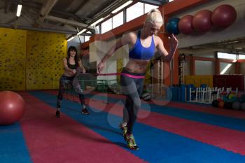 Young Couple Train Together With Resistance Bands A Leg Exercise In A Health And Fitness Concept