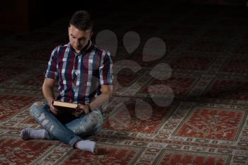 Humble Muslim Man Is Reading The Koran In The Mosque