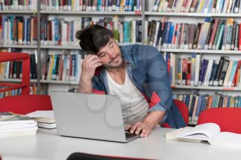 Stressed Student in High School Sitting at the Library Desk