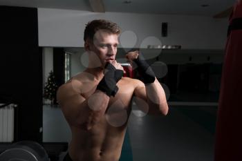 Young Man Boxing On Bag - Boxing In A Gym - The Concept Of A Healthy Lifestyle - The Idea For The Film About Boxing
