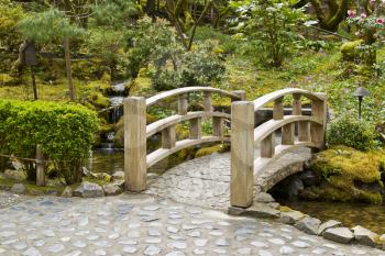 Wooden bridge crossing stream in Japanese Garden