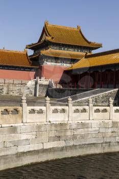Water and pathway in front of temple at the forbidden city in China with blue sky in background