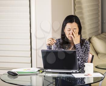 Mature women resting her eyes while working in home office