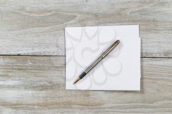 Top view of business envelope and writing pen on rustic white wooden desktop 
