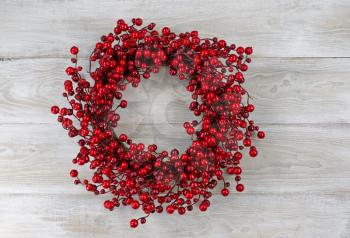 Red berry holiday wreath on old white boards 