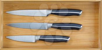 Close up horizontal image of inside a new wooden kitchen drawer with knife set 