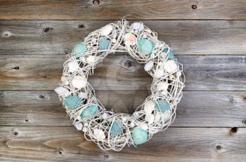 Seashell wreath on rustic wood. Layout in horizontal format.

