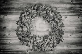 Vintage concept holiday natural leaf wreath made with real tree leaves on rustic wooden boards