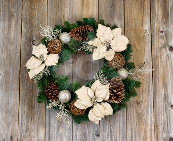 White Poinsettia flower and pine cone Christmas wreath on rustic cedar wood. 