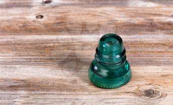 Antique electric glass insulator on rustic wood. 