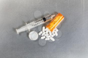 Flat view of painkiller pills with open bottle and syringe. Opioid epidemic concept.