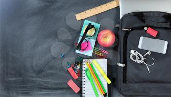 Back to School with modern technology and traditional items on chalkboard background