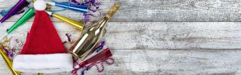 Happy New Year concept with golden champagne, Santa hat and party decorations 
