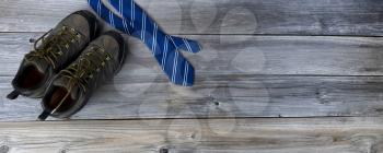 Work shoes with blue necktie for Fathers Day Concept background on vintage wooden planks 