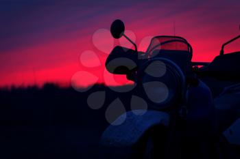 Silhouette of motorbike against sunset sky